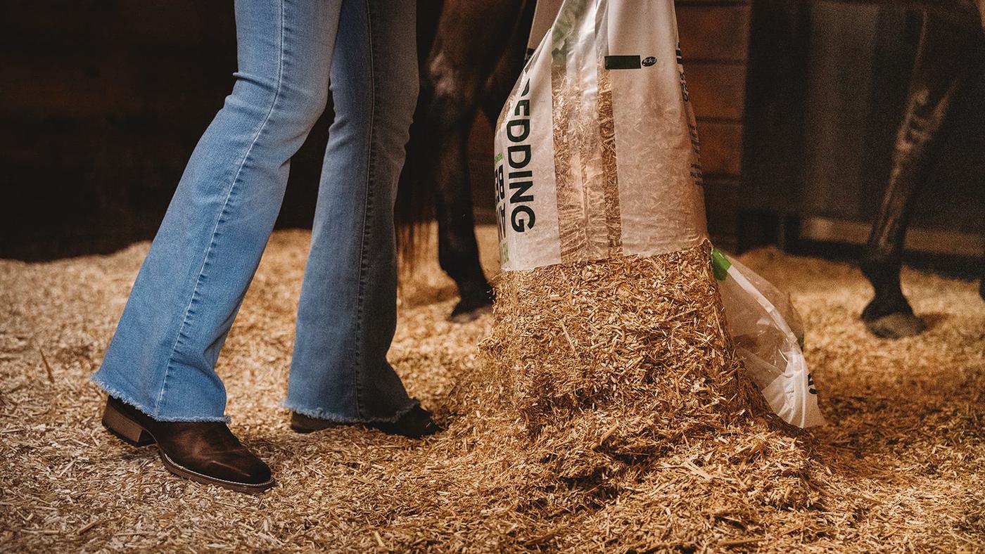 REVIVE animal bedding being poured in a horse stall